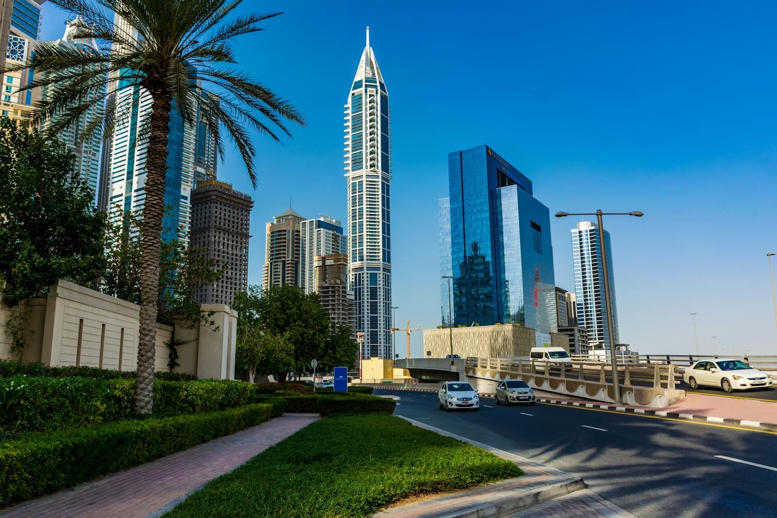 A modern Dubai Marina residential tower against a clear blue sky