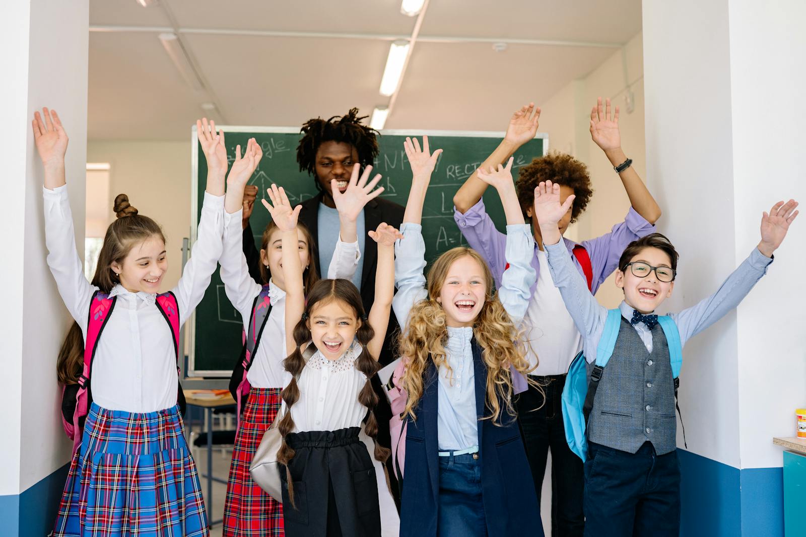A diverse group of school children in uniform smiling in a contemporary classroom